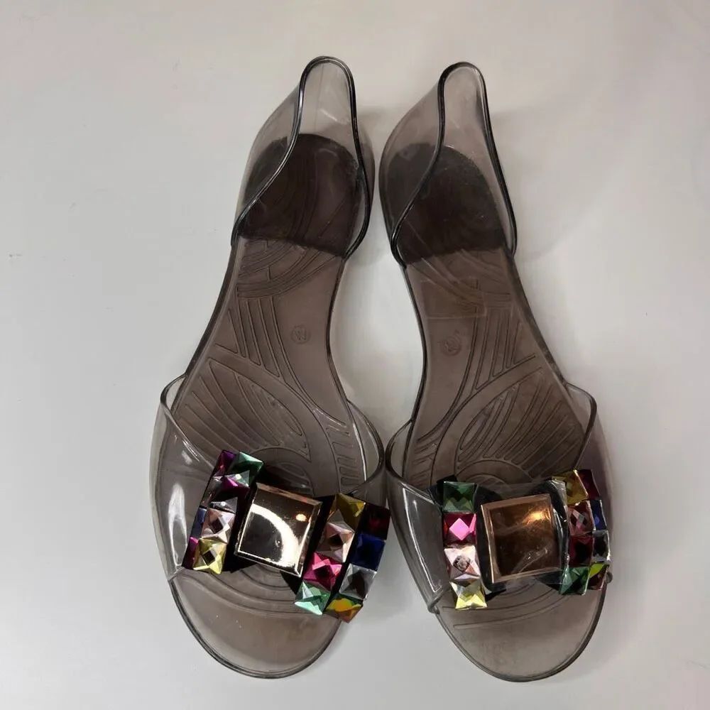 jelly flat sandals in a translucent smoke-gray color featuring large decorative